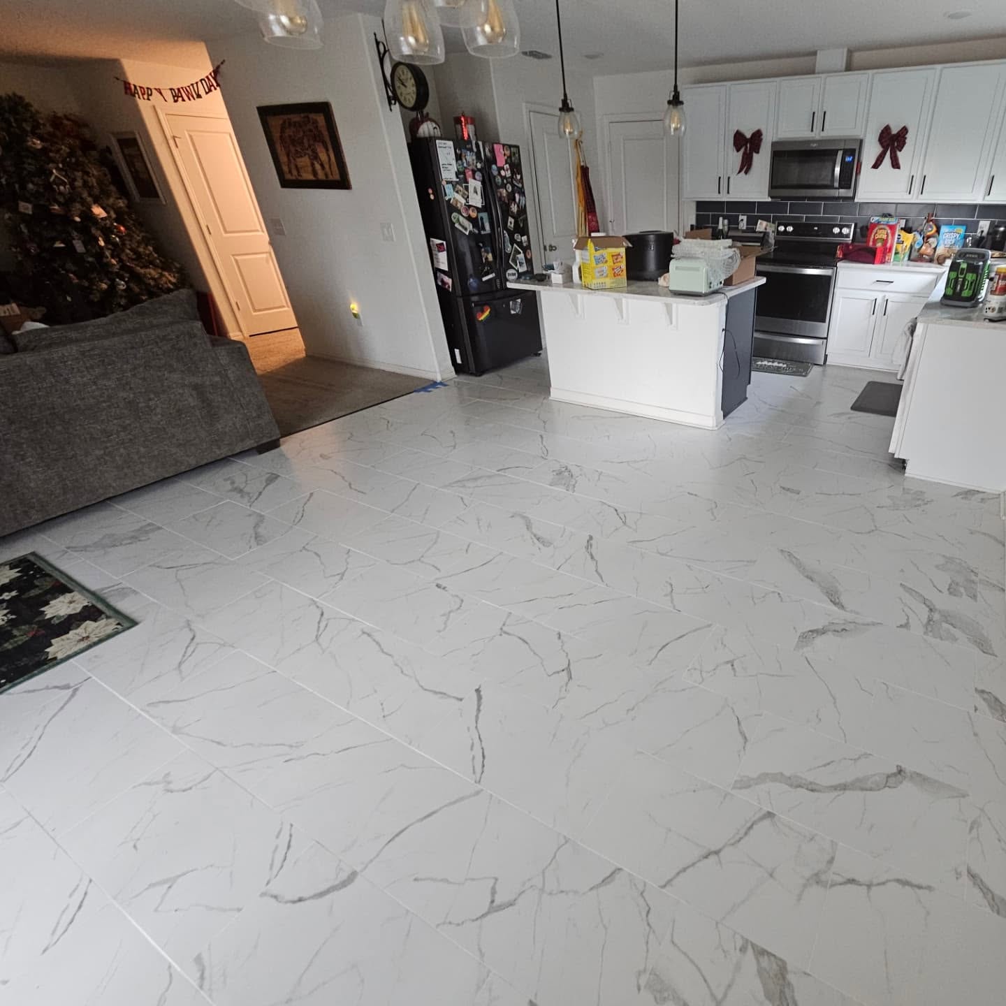 Large light tile floor installed through an open kitchen and living area